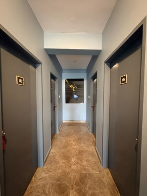 Un pasillo con puertas numeradas 102 y 105, que dan a habitaciones.
