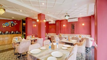 A restaurant interior with multiple dining tables, chairs, and a patterned floor.