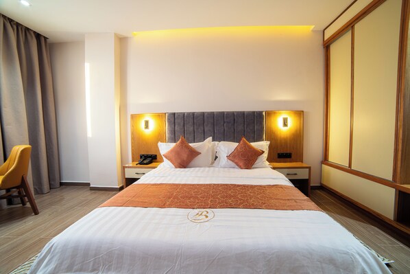 A hotel room with a bed, bedside tables, a chair, and a large window. - Barkat hôtel (Algiers)