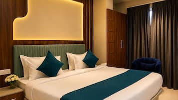 A modern hotel room with a large bed, a ceiling fan, and a nightstand with a vase of flowers.