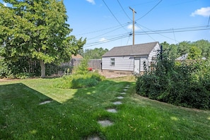 A residential property with a well-maintained lawn, a wooden fence, and a house with a gabled roof. - Modern Retreat in Heart of Montana near Airport (Billings)