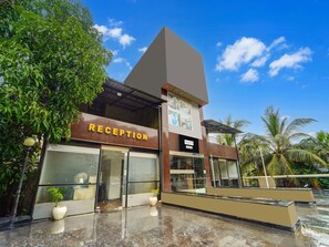 A modern building with a reception area, a visible sign for a palette, and a glass facade. - Classic Aveeno Villas (Saligao)