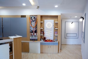 Una zona de recepció amb un senyal de registre d'entrada i sortida, una paret de pregàries i un petit santuari.
