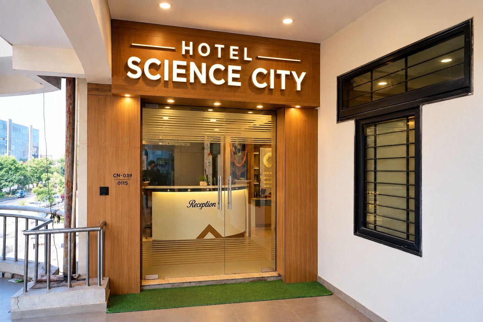A hotel entrance with a reception desk, a wooden facade, and a window with blinds.