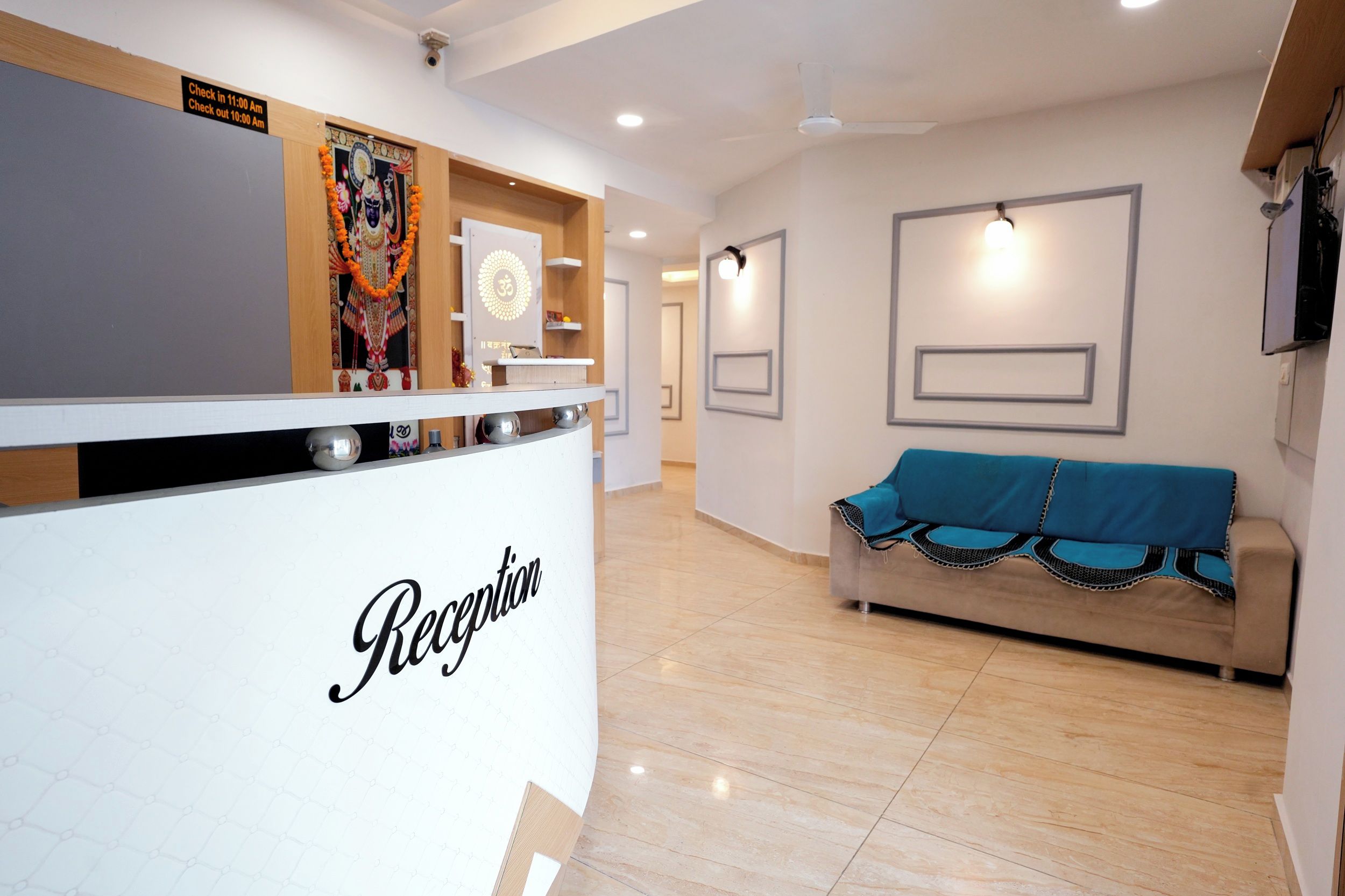A reception area with a reception desk, a sofa, and a wall-mounted light fixture.