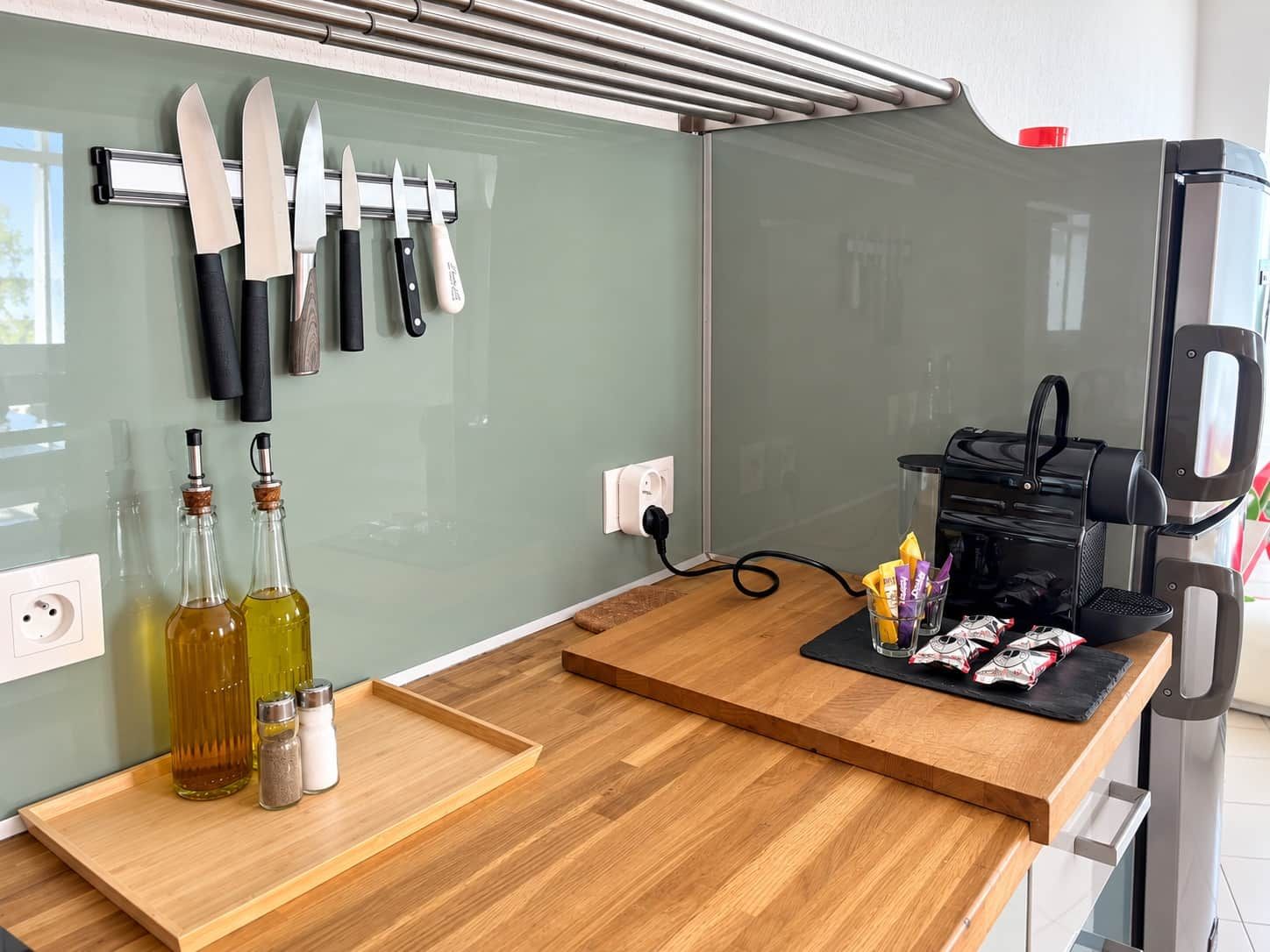 A kitchen with a wooden countertop, a coffee machine, and various kitchen utensils.
