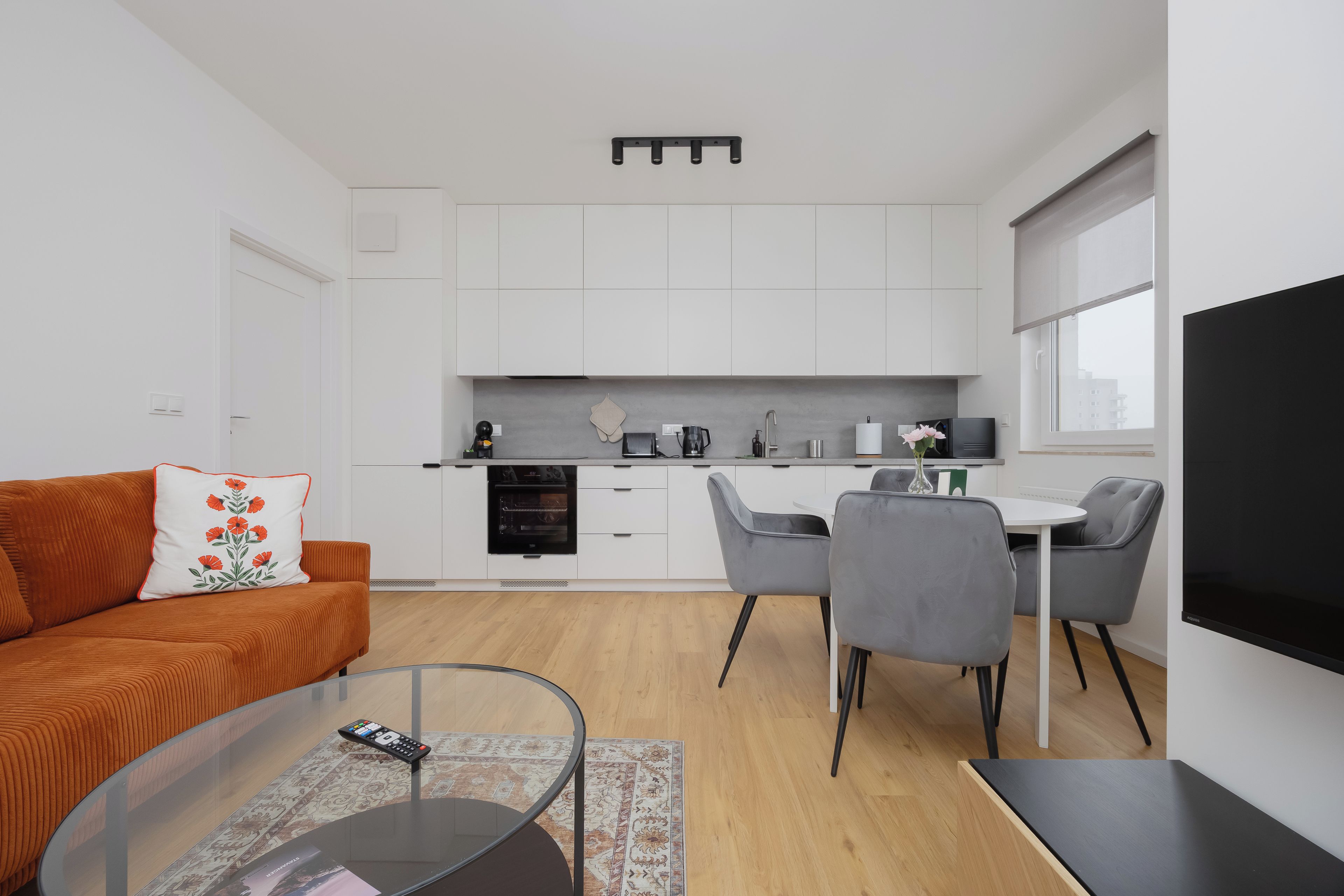 Un appartement moderne comprenant un espace de vie, une cuisine et un coin repas.