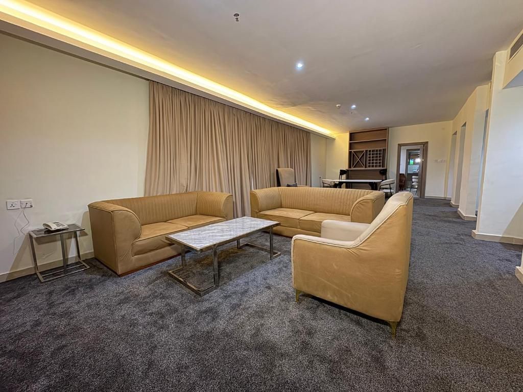 A living room with a sofa set, a coffee table, and a carpeted floor.