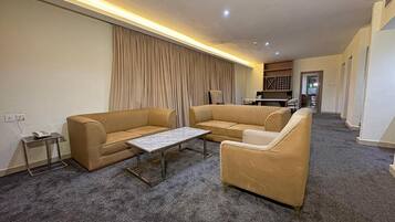 A living room with a sofa set, a coffee table, and a carpeted floor.