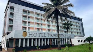 Un hotel de varios pisos con un letrero llamativo que dice 'HOTEL PRESIDENTIAL'.