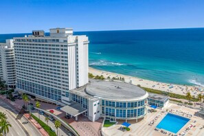 Ein Hochhaus-Hotel mit Pool und Blick auf den Strand.