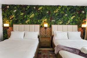 Ein Hotelzimmer mit zwei Betten, einer Wanddekoration und Nachttischlampen.
