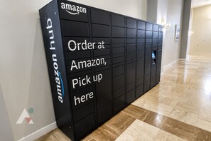 Un point de collecte Amazon Hub noir, avec des instructions indiquant comment passer commande sur Amazon et récupérer le colis ici.