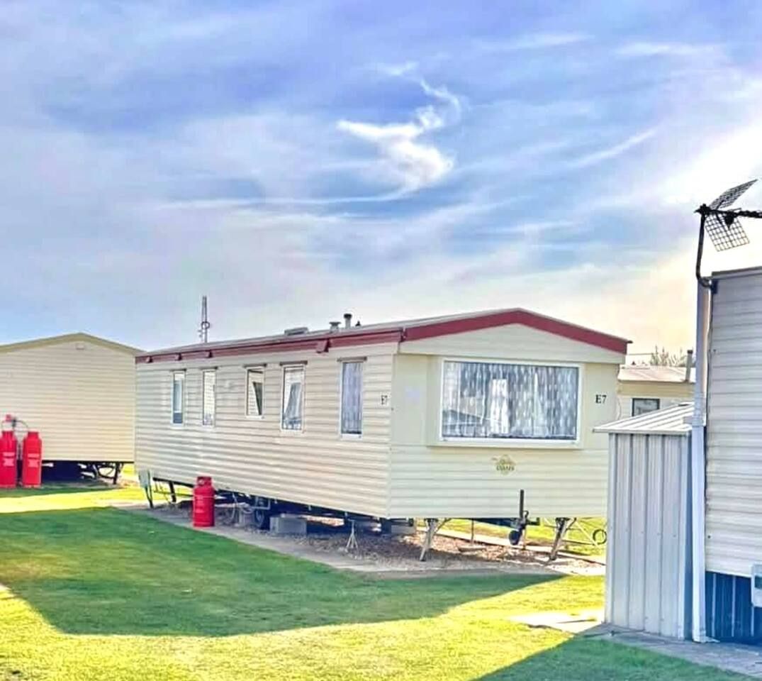 Une maison mobile avec un toit rouge, une fenêtre et un petit garage attenant.
