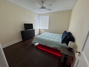 A bedroom with a bed, a dresser, a ceiling fan, and a window with blinds. - 1br apartment in NLR (North Little Rock)