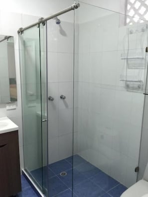 A glass-enclosed shower stall with a white tiled wall and a blue floor. - Hotel Casa Mara by Akel Hotels (Cartagena de Indias)
