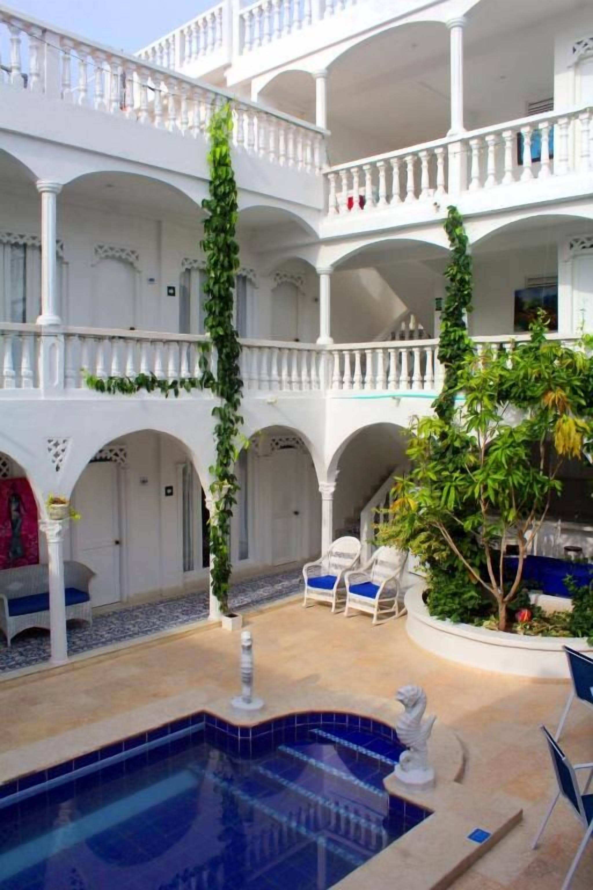 A multi-level courtyard with a swimming pool, seating areas, and a fountain.