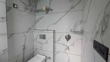 Une salle de bain avec des toilettes, une douche et un lavabo.