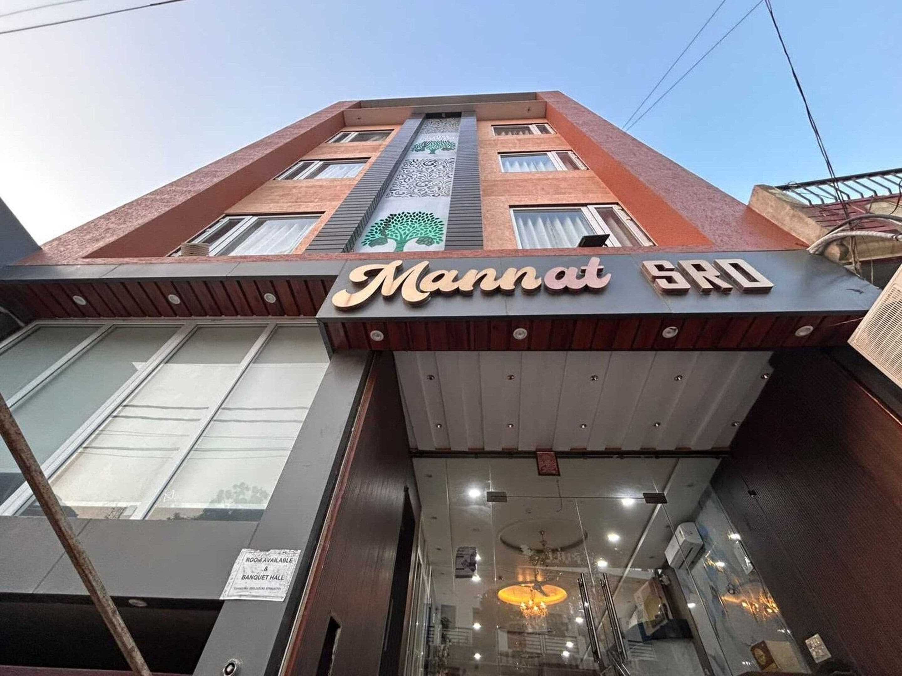 Un edifici amb un senyal que diu 'Mannat SRO' i un senyal que indica una habitació disponible per reservar.