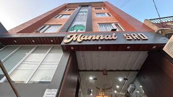 Un edifici amb un senyal que diu 'Mannat SRO' i un senyal que indica una habitació disponible per reservar.