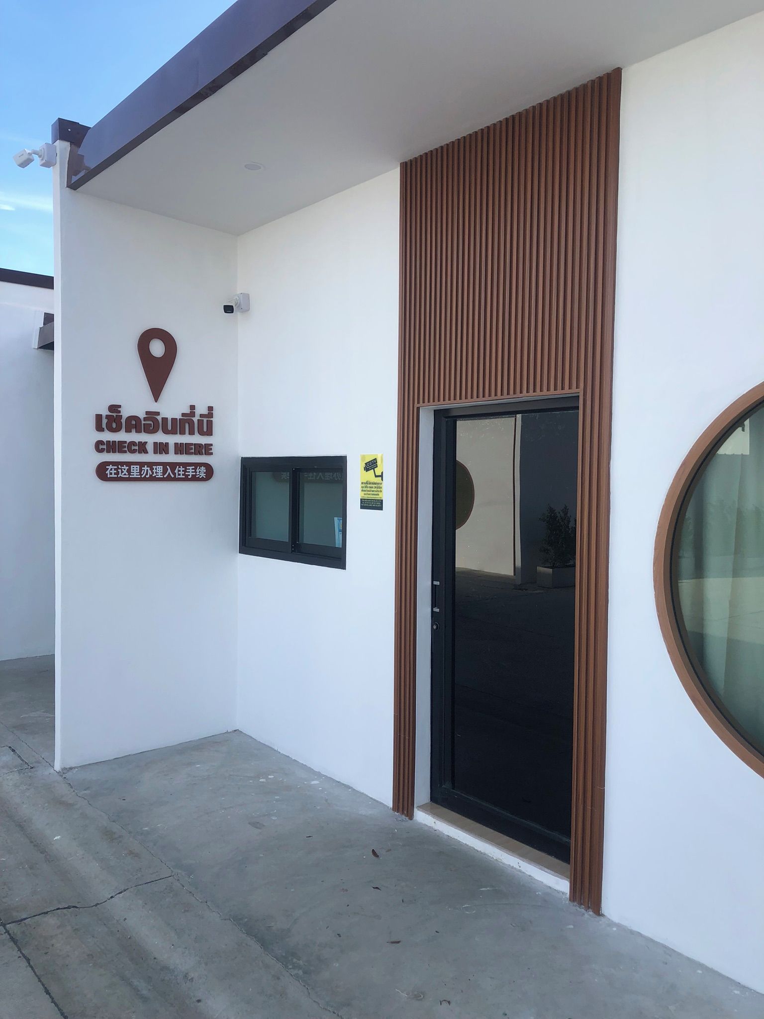 A building with a check-in sign, a location marker, and a door with a window.