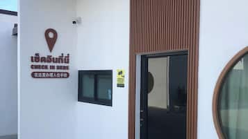 A building with a check-in sign, a location marker, and a door with a window.