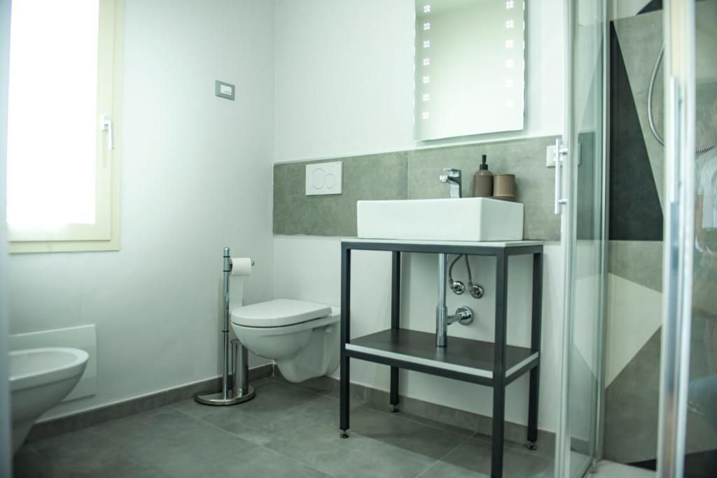 Ein modernes Badezimmer mit Toilette, Waschbecken und Dusche.