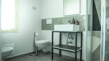 Ein modernes Badezimmer mit Toilette, Waschbecken und Dusche.