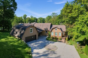 Une maison à deux étages avec un garage, une allée couverte et une pelouse bien entretenue.