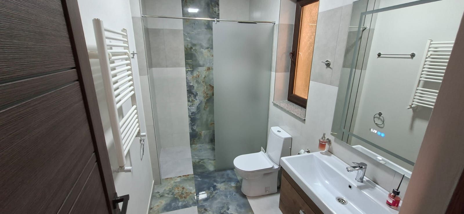 A bathroom with a shower, toilet, and sink.