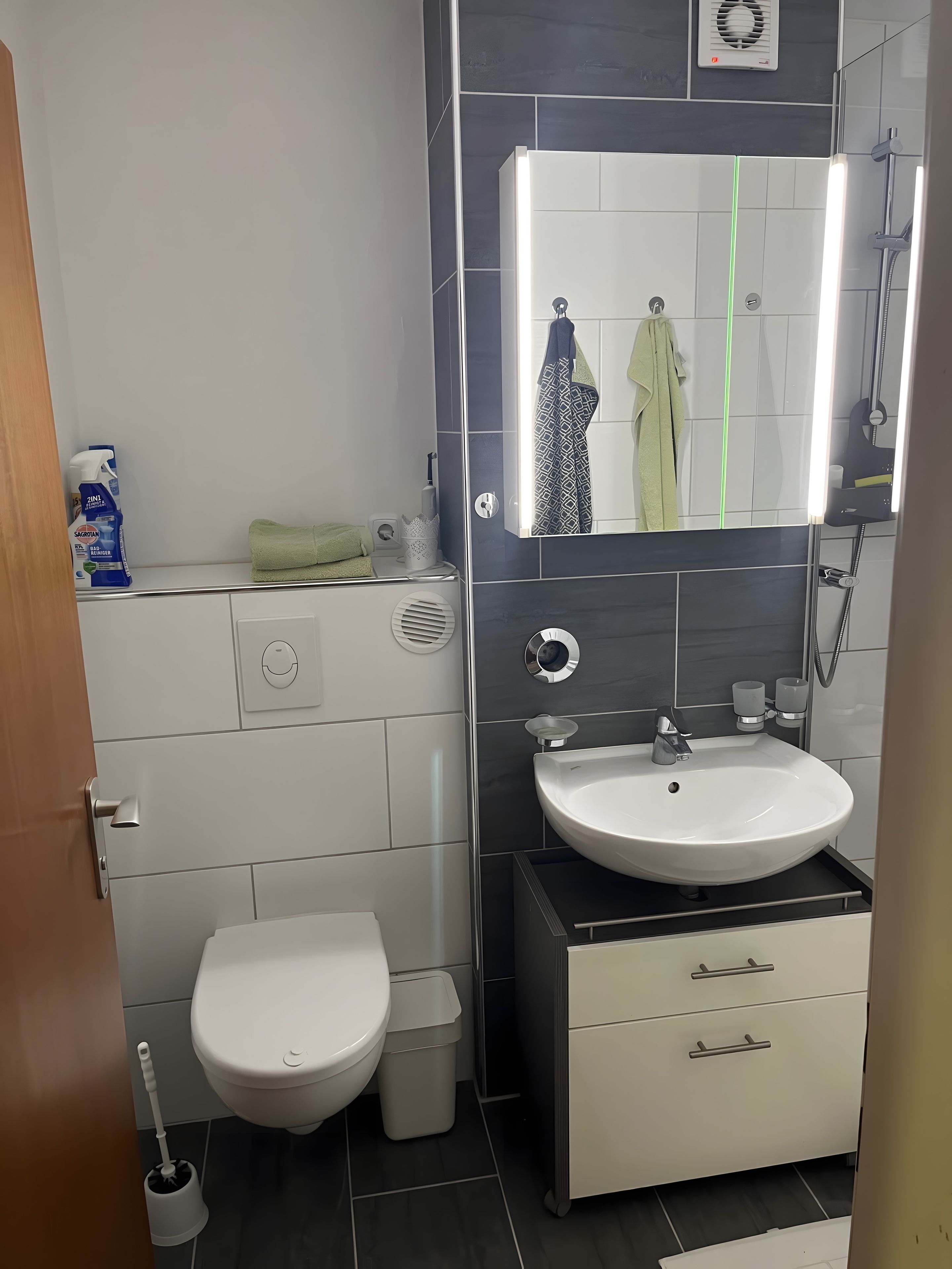A modern bathroom with a toilet, sink, and shower.