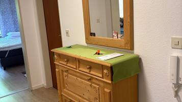 Ein Holzkleiderschrank mit Spiegel, einem grünen Tuch und einem Schlüsselanhänger.