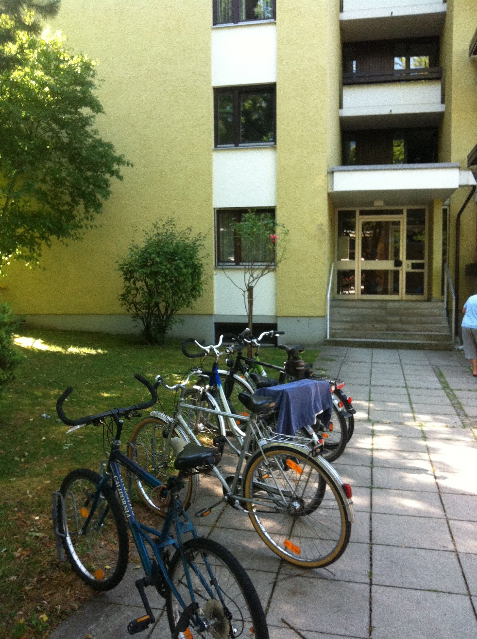 Bicicletas estacionadas em frente a um edifício com porta e janelas.