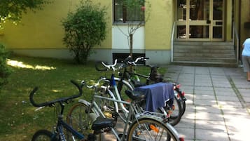 Bicicletas estacionadas em frente a um edifício com porta e janelas.