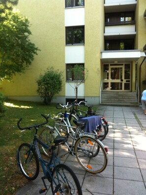 Bicicletas estacionadas em frente a um edifício com porta e janelas.