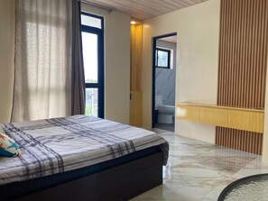 Een slaapkamer met een bed, een badkamer en uitzicht naar buiten.