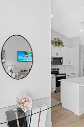 A modern kitchen with white cabinetry, a microwave, and a stove. - Waterfront Retreat - Pool, Dock, 3 Min to Bonita Beach (Bonita Springs)