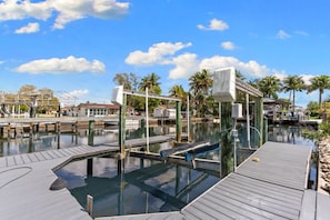 A marina with wooden docks, clear water, and a few boats. - Waterfront Retreat - Pool, Dock, 3 Min to Bonita Beach (Bonita Springs)