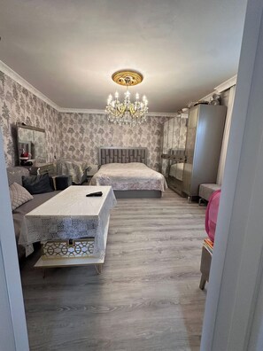 Ein Schlafzimmer mit zwei Betten, einer Kandelaber, einem Schminktisch und einem Spiegel.