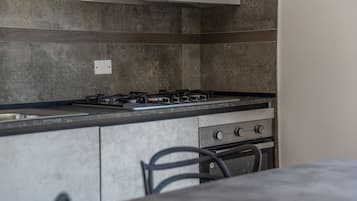 A modern kitchen with a gas stove, a sink, and a built-in oven.