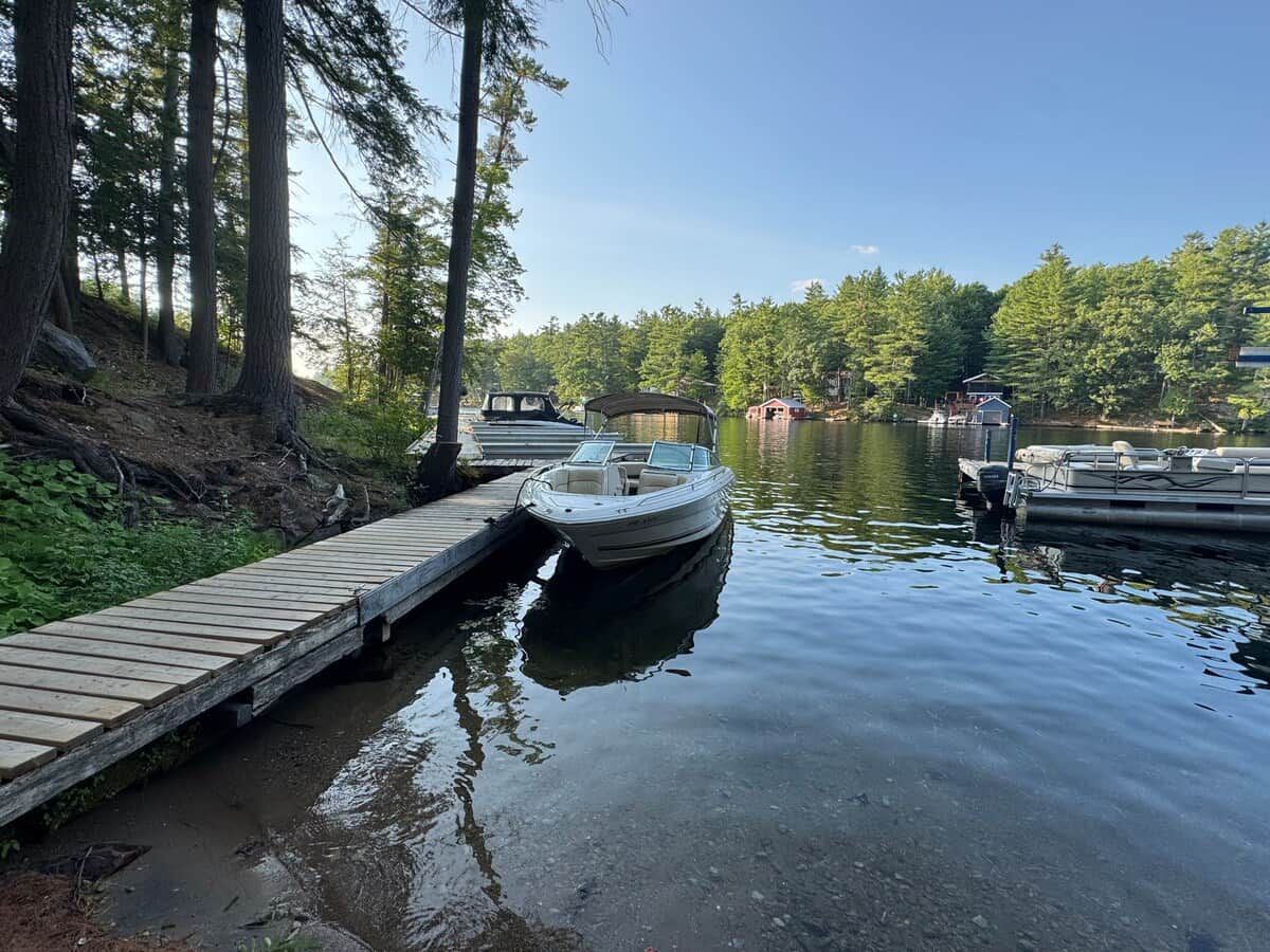 Un lac paisible avec un quai en bois menant à un bateau.