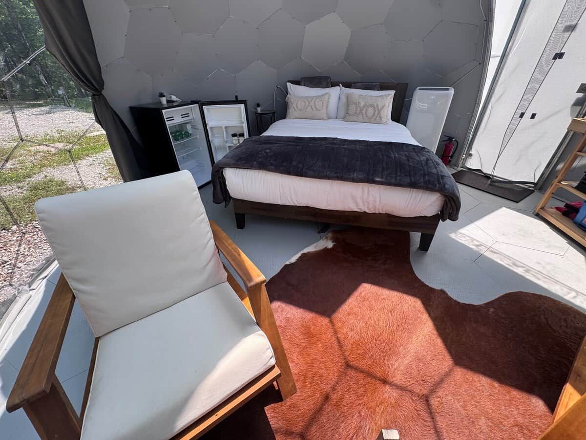 Ein Schlafzimmer mit einem Bett, einem Sessel, einem kleinen Tisch und einem Kleiderschrank.