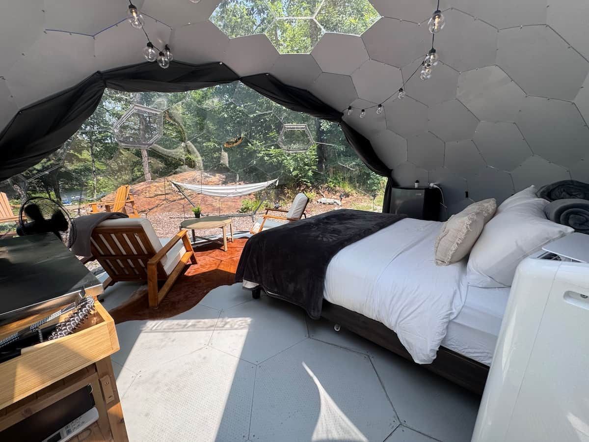 A tent-style bedroom with a bed, a desk, and a chair.