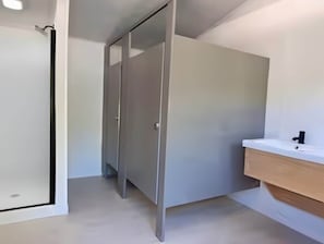 Un baño con lavamanos blanco, un espejo y un perchero para toallas.