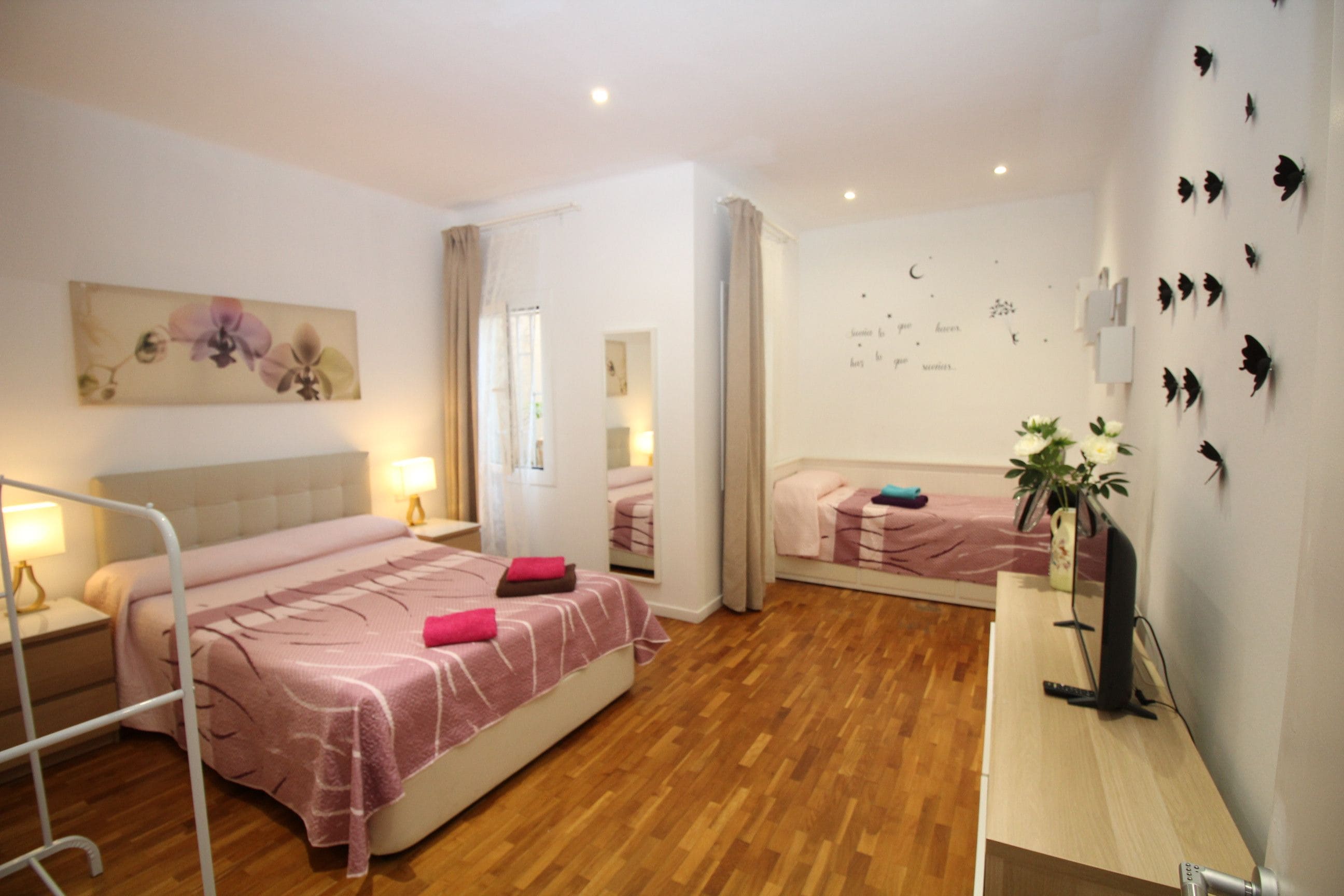 Habitación de hotel con cama, mesita de noche, lámpara y una pared con detalles decorativos.