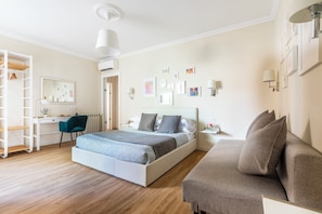 Une chambre à coucher comprenant un lit, un bureau, une chaise, une armoire et un canapé.