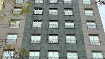 Un edificio de varios pisos con un estilo arquitectónico uniforme, con ventanas y balcones distribuidos de manera regular.