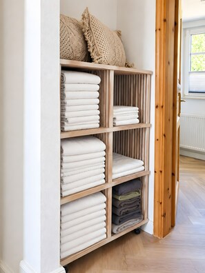 A wooden shelving unit with neatly folded towels in various colors. - Holiday Home 'Natürlich Am Bodden' with Lake View, Private Terrace and Wi-Fi (Fuhlendorf)