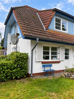 A house with a tiled roof, white shutters, and a blue bench outside. - Holiday Home 'Natürlich Am Bodden' with Lake View, Private Terrace and Wi-Fi (Fuhlendorf)