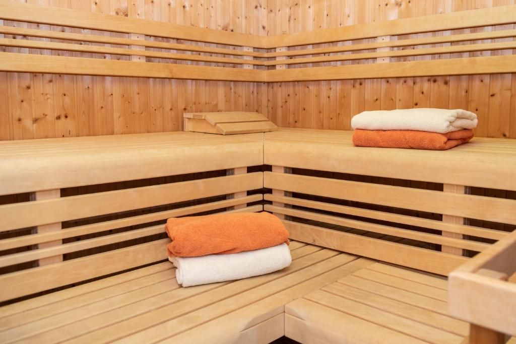 A sauna with wooden benches and benches, towels, and a bench with a towel on it.